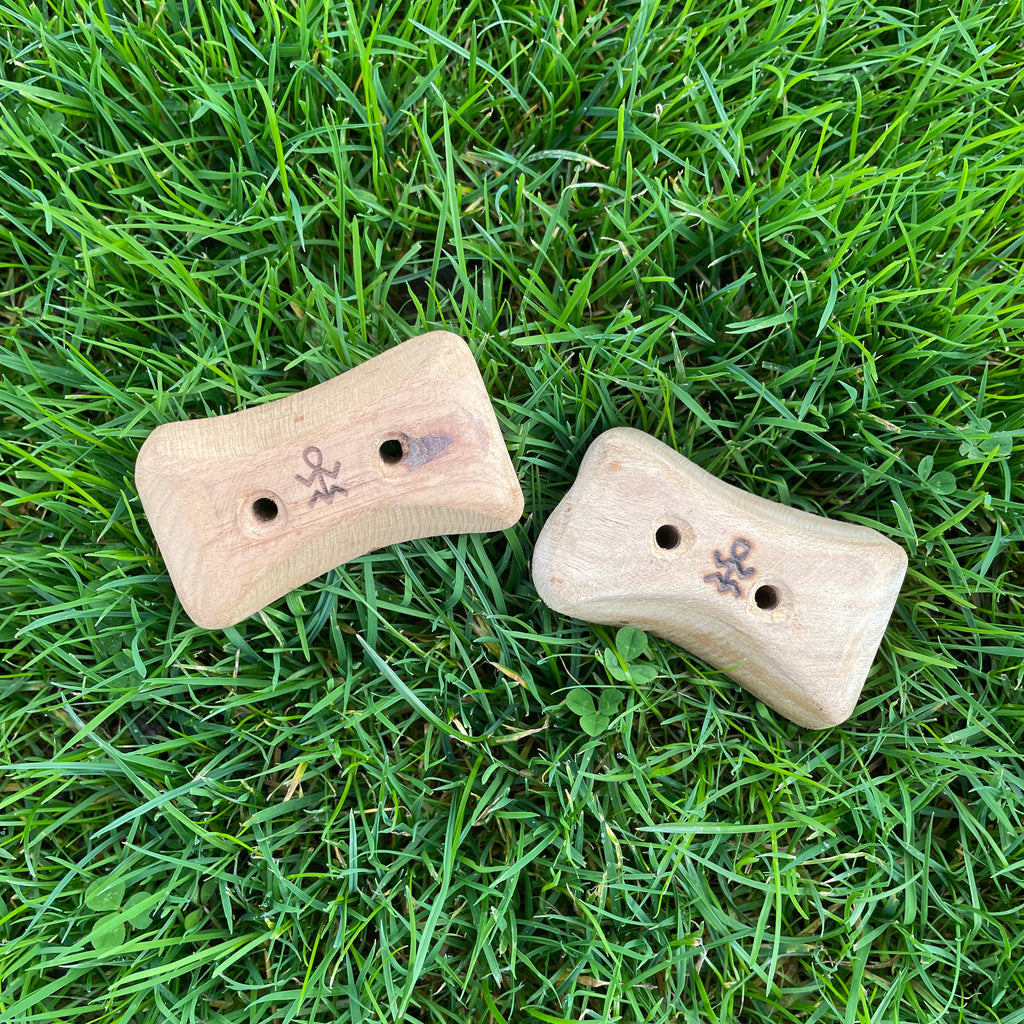 wooden climbing pinch holds laying in the grass
