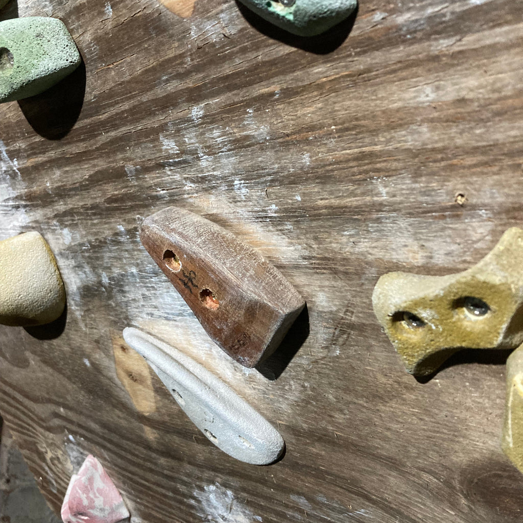 crimpy wooden climbing hold screwed onto board