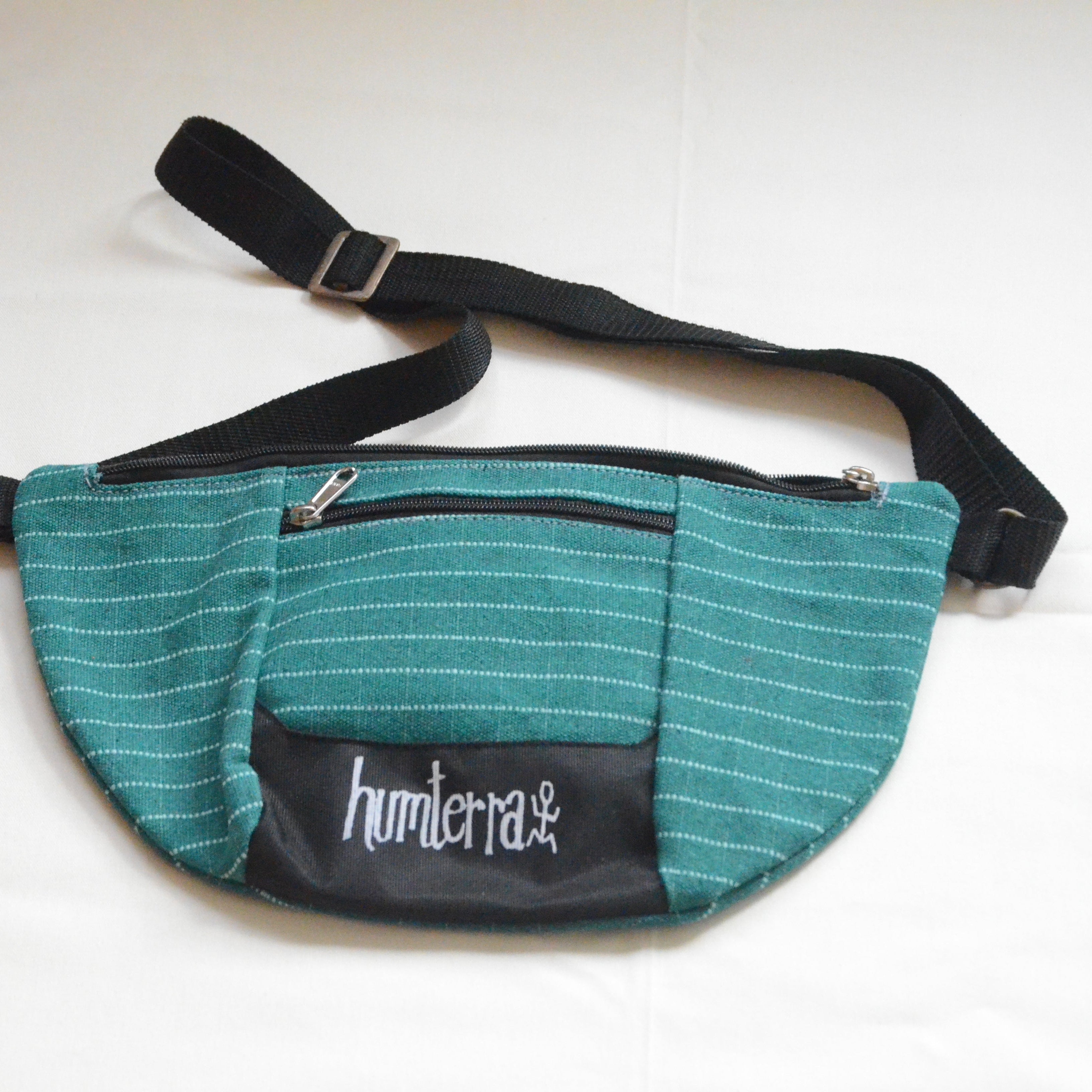 Green waist bag with black strap and humterra branding on a white background