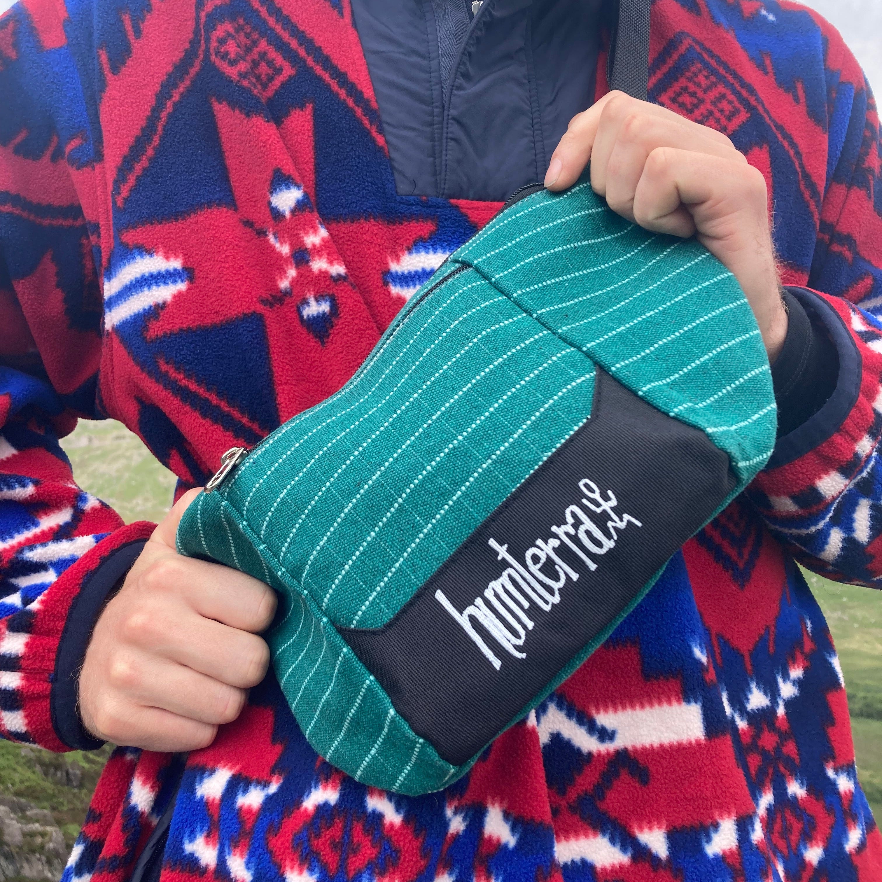 Person holds the humterra branded Cross Body Bag in front of the body