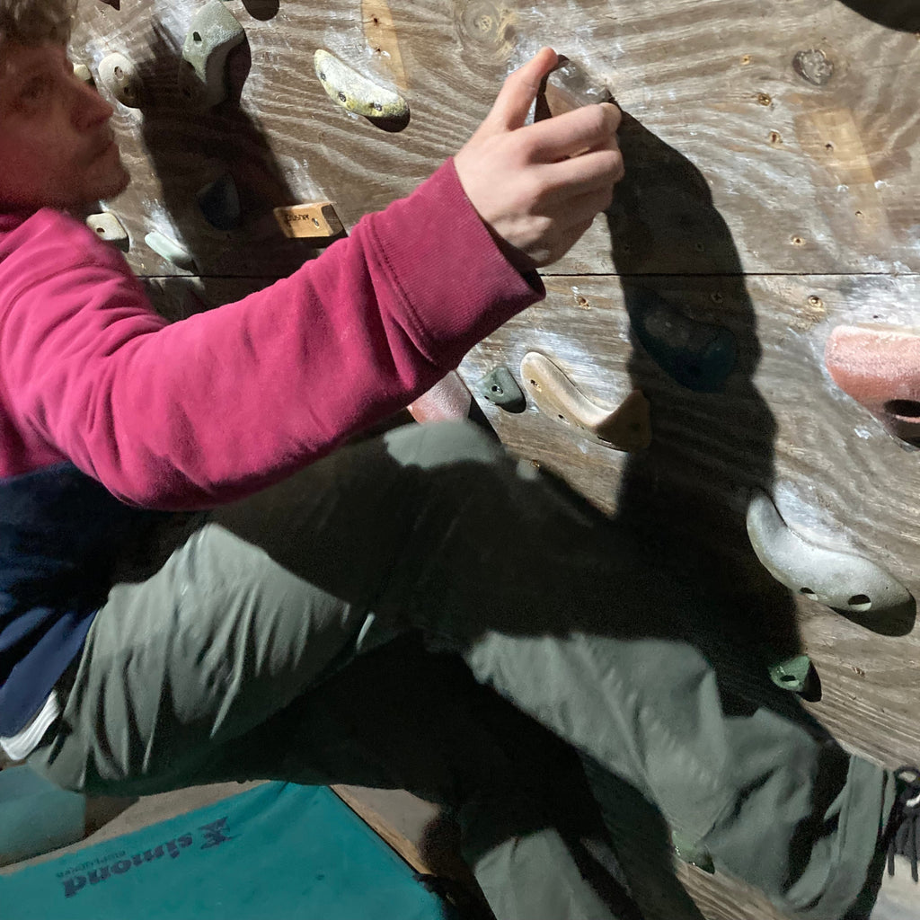 Person climbing on a rock wall with hands on holds