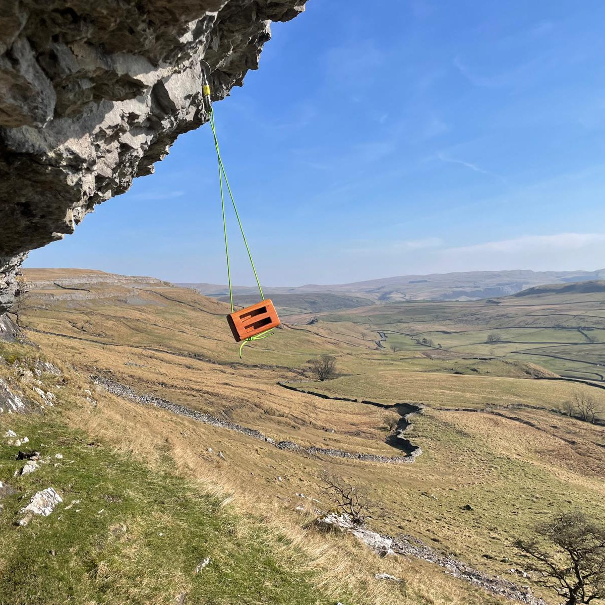wooden hangboard swinging from paracord in Peak District