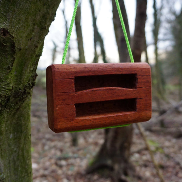 wooden hangboard hanging from tree with green paracord