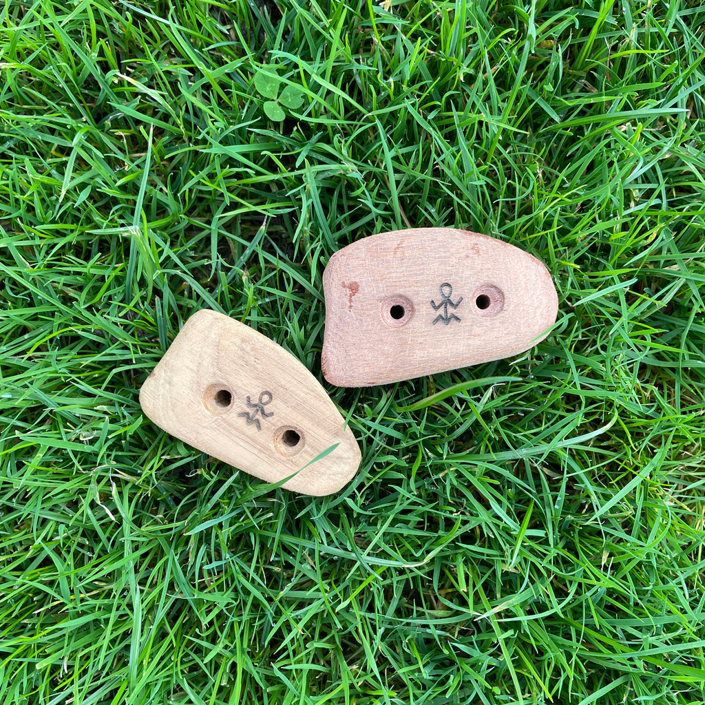 wooden climbing holds laying in grass